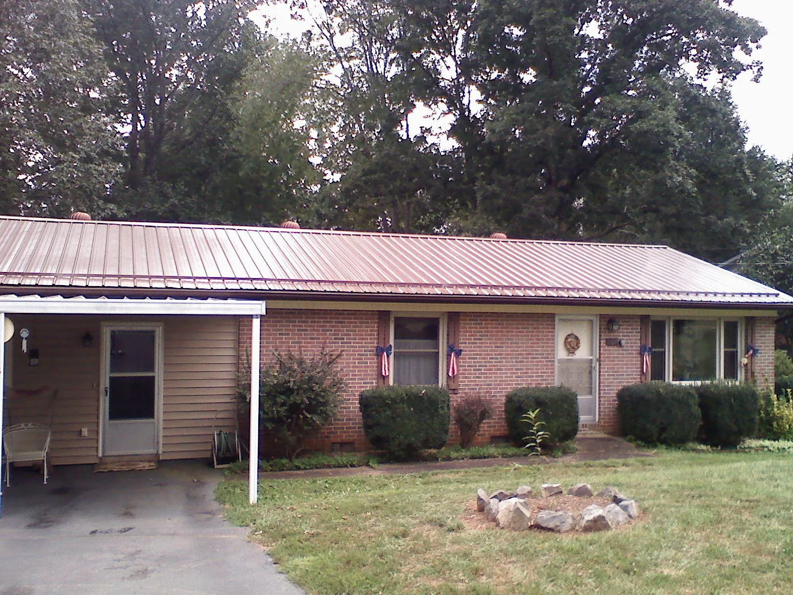 Bronze metal roof and carport on a brick ranch home — Roof Repair work by our crew in Orting